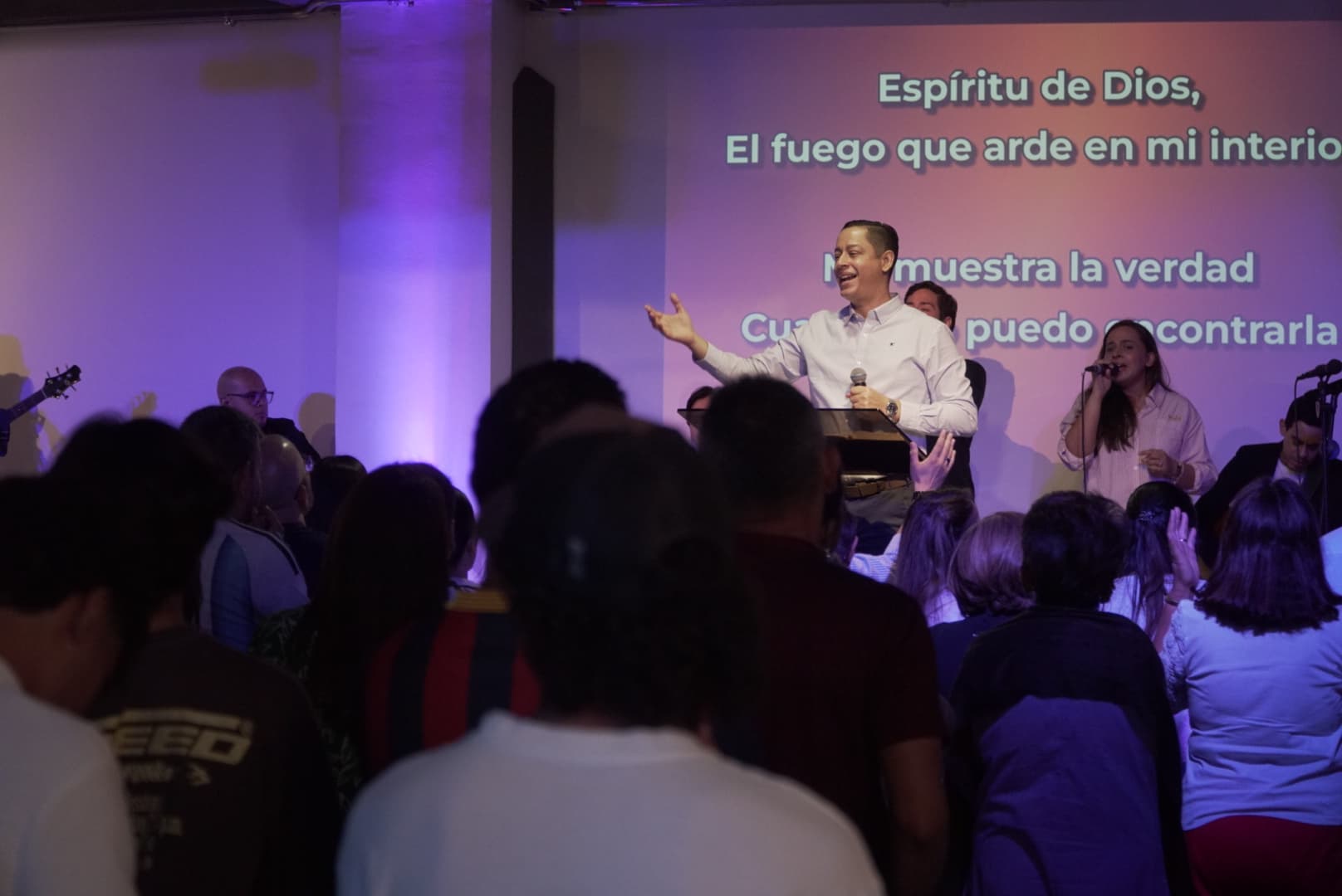 La congregación de pie frente a la tarima durante la alabanza